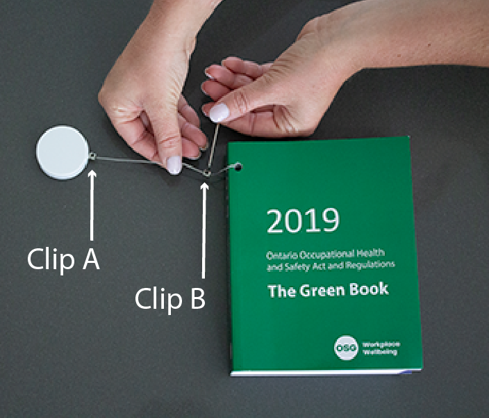 Green Book with Retractable Cord Attached and Clips on Cord - upper clip labelled A, lower clip labelled B