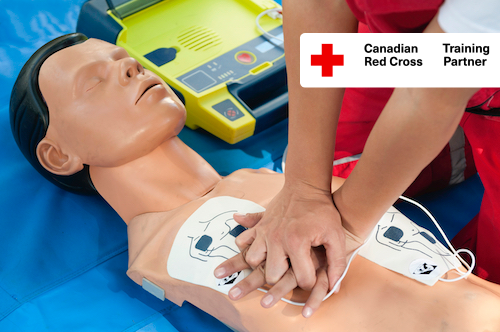 Close up of hands preforming chest compressions combined with AED defibrillator operation performed on a CPR mannequin