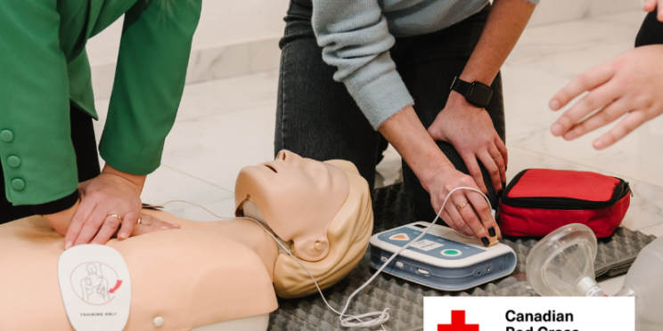 OSG facilitators demonstrating using an AED on a first aid mannequin during training.